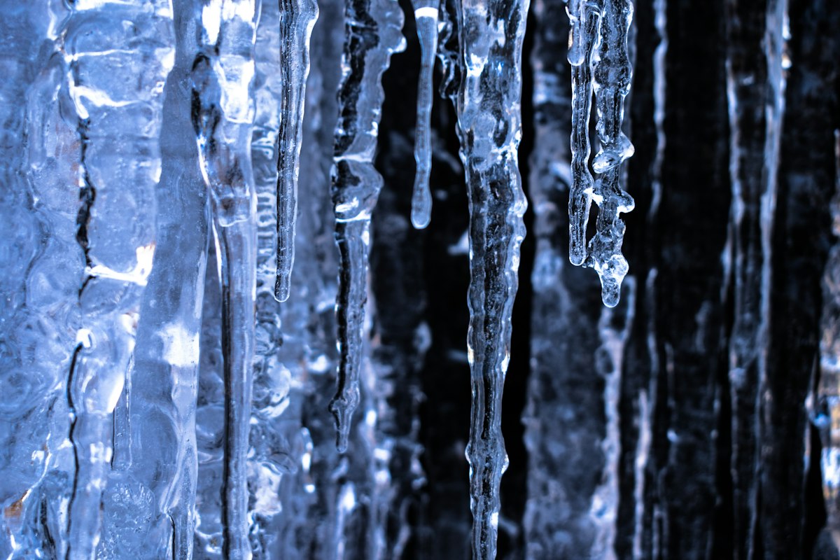 Icicles hanging from a roofline showing winter ice dam risk